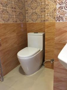 a bathroom with a white toilet and a sink at Hotel Lilyland Pvt Ltd in Pokhara