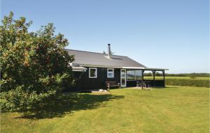 ein kleines schwarzes Haus mit einem großen Hof in der Unterkunft Cozy Home In Hjslev With House Sea View in Lund