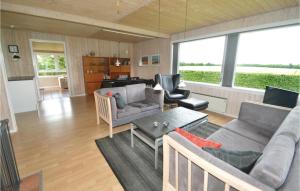 ein Wohnzimmer mit einem Sofa und einem Tisch in der Unterkunft Cozy Home In Hjslev With House Sea View in Lund