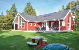 a red barn with a table in the yard at Nice Home In Oksbl With 4 Bedrooms, Sauna And Wifi in Mosevrå