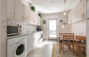 アリンエにある1 Bedroom Amazing Apartment In Allingeのキッチン(洗濯機、テーブル、椅子付)