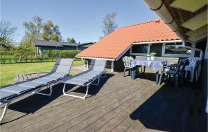 a wooden deck with a table and chairs and a roof at Three-Bedroom Holiday Home In Sydals in Skovbyballe