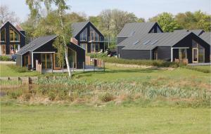 a group of houses in a field with a yard at Amazing Home In Stubbekbing With 3 Bedrooms in Stubbekøbing