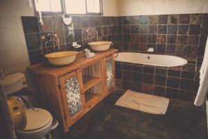 a bathroom with two sinks and a tub and a toilet at Grincourt B&B- with No Load shedding in Polokwane