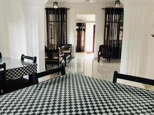 a room with a bed with a black and white checkered floor at Bon Voyaage Tourist Inn in Trincomalee