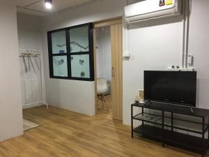 a living room with a flat screen tv and a window at Hello House in Krabi town