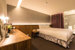 a hotel room with a bed and a desk at Goodmore Hotel in Taipei