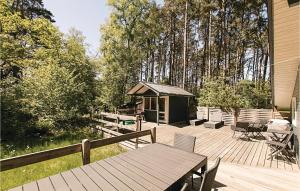 a wooden deck with a picnic table and a gazebo at Holiday Home Munkegårdsskoven Nexø Ix in Spidsegård +8 photos