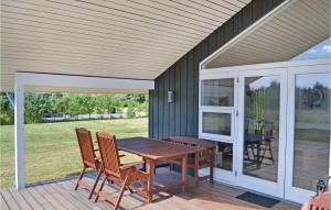 eine Terrasse mit einem Holztisch und Stühlen auf einer Terrasse in der Unterkunft Sanglærken in Øksenmølle + 27 Fotos