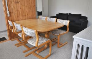 uma mesa de madeira com quatro cadeiras e um sofá em Stunning Apartment In Sydals With Kitchen em Tandslet