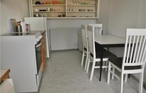 a kitchen with a table and chairs and a refrigerator at One-Bedroom Apartment In Sydals in Tandslet