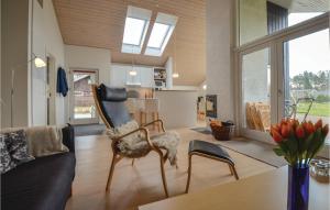 ein Wohnzimmer mit einer Couch und einem Sessel in der Unterkunft Sanglærken in Øksenmølle