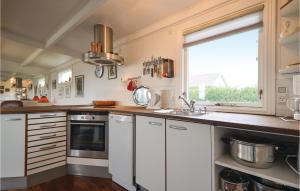 una cucina con mobili bianchi, un lavandino e una finestra di Three-Bedroom Holiday Home In Ebeltoft a Ebeltoft