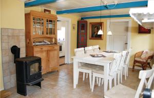 1 Bedroom Awesome Home In Nrre Nebel في Nymindegab: مطبخ وغرفة طعام مع طاولة وموقد
