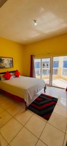 een slaapkamer met een groot bed en een balkon bij Spring Palm Estate in St Mary