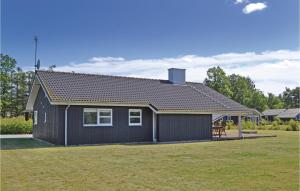 ein kleines schwarzes Haus mit einem großen Garten in der Unterkunft Sanglærken in Øksenmølle