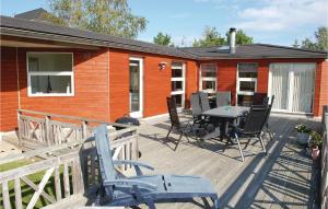 eine Terrasse mit einem Tisch und Stühlen auf einem Haus in der Unterkunft 4 Bedroom Awesome Home In Ebeltoft in Ebeltoft