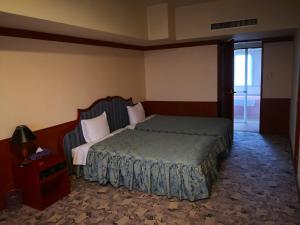 a bedroom with a bed and a dresser and a door at Furano Hops Hotel in Kami-furano