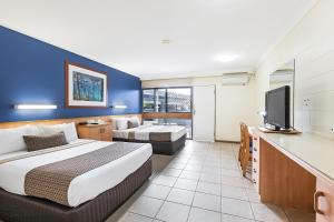 エアリービーチにあるReef Gateway Hotelのベッド1台、薄型テレビが備わるホテルルームです。