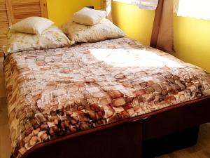 a bed with a quilt and pillows on it at Apartament Grota in Szklarska Poręba