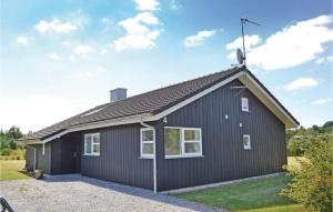 ein schwarzes Haus mit Dachschräge in der Unterkunft Sanglærken in Øksenmølle