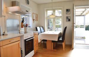 a kitchen with a table and a sink and a table and chairs at 3 Bedroom Beautiful Home In Dronningmlle in Dronningmølle