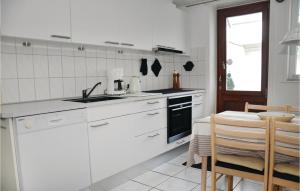 KegnæshøjにあるAwesome Apartment In Sydals With 2 Bedroomsのキッチン(白い家電製品、テーブル、椅子付)