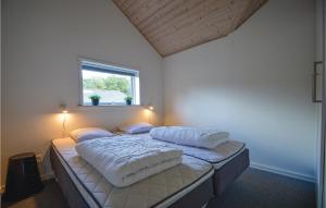 una camera da letto con un letto con due cuscini sopra di Holiday Home Sydmarken Toftlund I a Vestergård Altre 19 foto