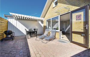 a patio with chairs and a table on a brick patio at Nice Home In Otterup With 1 Bedrooms And Wifi in Otterup