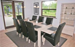 einen Esstisch mit schwarzen Stühlen und einem Tisch sowie einem Tisch und einem Chairsktop in der Unterkunft Nice Home In Jgerspris With 3 Bedrooms And Wifi in Hornsved