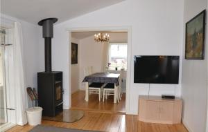a living room with a fireplace and a dining room table at Nice Home In Solrd Strand With Kitchen in Karlstrup Strand