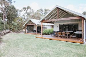 a home with a large deck and a dining area at Yallingup Villas in Yallingup