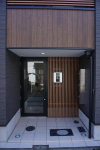 an entrance to a building with a wooden door at Sakura Shigure Shin-Osaka in Osaka