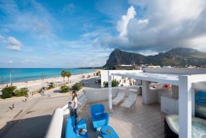 balcone con sedie blu e vista sulla spiaggia. di Residence Le Palme a San Vito lo Capo