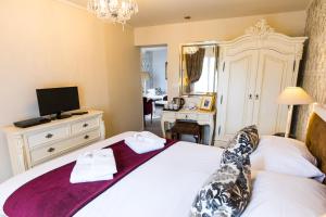 a hotel room with a bed and a television at Logis Hotel De France in La Chartre-sur-le-Loir