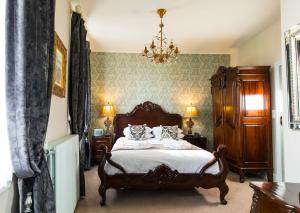 a bedroom with a bed and a chandelier at Logis Hotel De France in La Chartre-sur-le-Loir