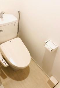 uma casa de banho com um WC e um rolo de papel higiénico em Izumi Apartment em Osaka