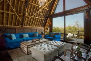 a living room with a blue couch and a table at Jeeva Beloam Beach Camp in Tanjung Ringgit
