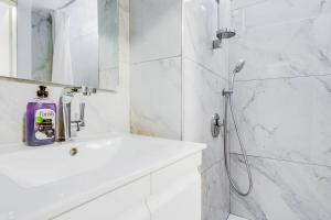 baño blanco con ducha y lavamanos en MAGNIFIQUE APPARTEMENT A 3' DE LA PLAGE ET KIKAR, en Netanya