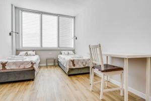 1 dormitorio con 2 camas, escritorio y silla en MAGNIFIQUE APPARTEMENT A 3' DE LA PLAGE ET KIKAR, en Netanya