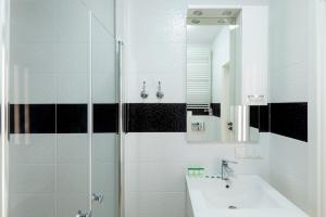 uma casa de banho branca com um lavatório e um espelho em Warsaw-Aparts Bukowinska 2 em Varsóvia
