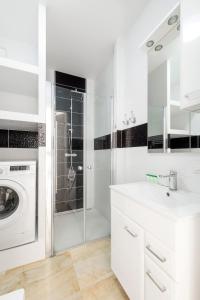 uma casa de banho branca com uma máquina de lavar roupa e um lavatório em Warsaw-Aparts Bukowinska 2 em Varsóvia