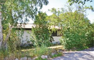 una casa blanca con árboles delante de ella en Nice Home In Solrd Strand With Kitchen, en Karlstrup Strand