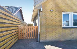 a wooden fence next to a brick building at One-Bedroom Holiday Home In Otterup in Otterup