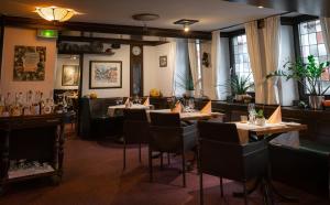 ein Restaurant mit Tischen und Stühlen in einem Raum in der Unterkunft Hotel Wilder Mann in Aschaffenburg