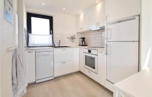 a white kitchen with white appliances and a window at One-Bedroom Holiday Home In Otterup in Otterup