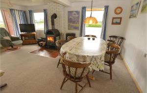 une salle à manger avec une table, des chaises et une cheminée dans l'établissement Stunning Home In Egernsund With Kitchen, à Egernsund