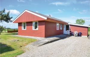 a red house with two chairs in front of it at Three-Bedroom Holiday Home In Egernsund in Egernsund