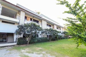 an apartment building with a yard in front of it at OYO 421 Dnk Baan Suan in Lamphun