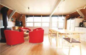 a kitchen and dining room with a table and red chairs at Holiday Home Brombærvænget Humble Vi in Humble +15 photos